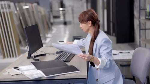 Businesswoman reviewing documents at her desk
