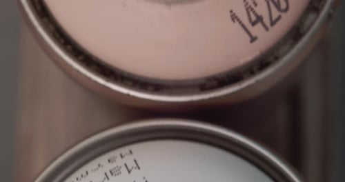 Close Up Top View Of Spray Paint Cans In Different Colors. overhead