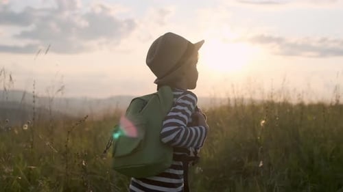 Child Hiker Walking in Field at Golden Hour