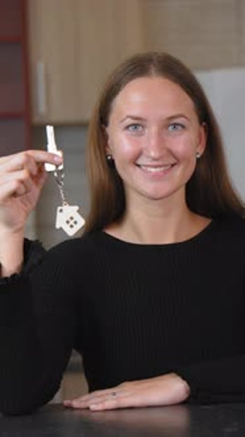 Agent immobilier présentant joyeusement les clés de la maison avec un sourire éclatant