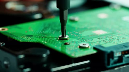 Screwing in Green Circuit Board Close Up