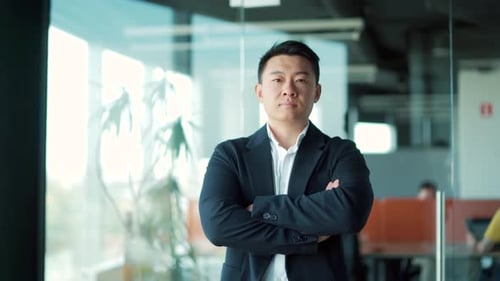 portrait of a successful confident asian male office worker standing and looking at the camera