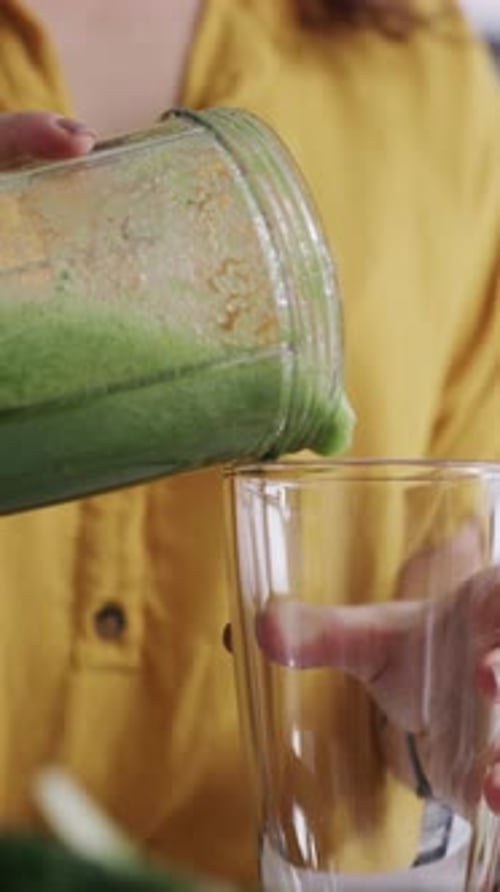 Frau, Hände und Mixer mit grünem Saft oder Smoothie für Ernährung, Vitamine oder Diät zu Hause
