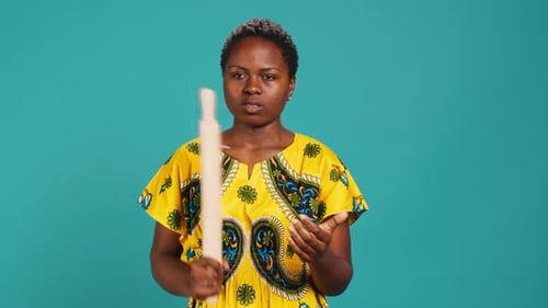 Woman Holding a Rolling Pin Talking to Camera