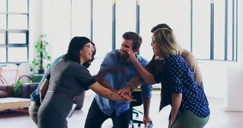 Teamwork, unity and fun at the workplace with a professional group joining hands in an office