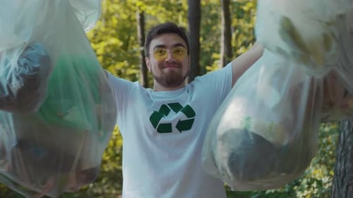 Un hombre se enfrenta a los residuos plásticos en la naturaleza que simbolizan los problemas ambientales