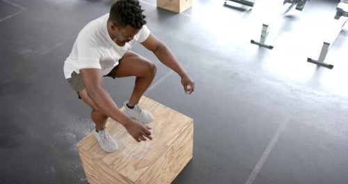 Fit African American man performs a step-up exercise at the gym