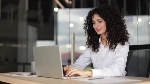 Focused Businesswoman Working on Laptop in Modern Office