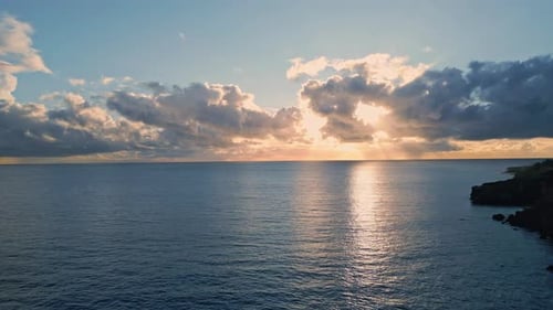 Picturesque sunrise over the endless ocean reflecting pastel sun beams in super slow motion