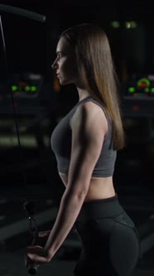 Sporty Woman in the Gym Lifting Blocks on Gym Machine Strength Training on Block Device and Gym