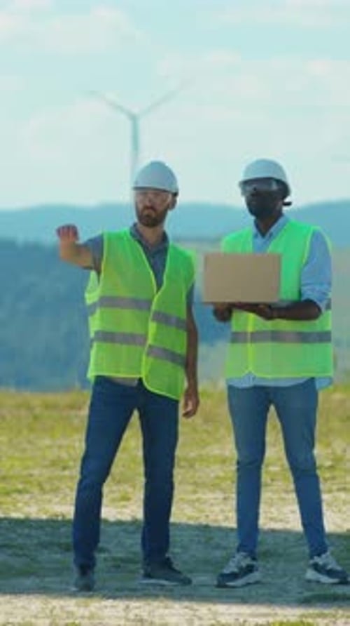 A Group of Engineers is Collaborating Effectively at the Site of a Wind Farm Project