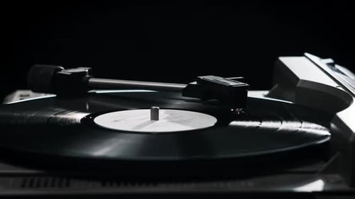 Hand Adjusts Needle on Record Player Spinning Vinyl