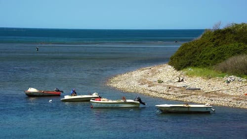 An einer ruhigen Meeresbucht geparkte Fischerboote, Fischer bereiten die Netze und den Angelhaken vor