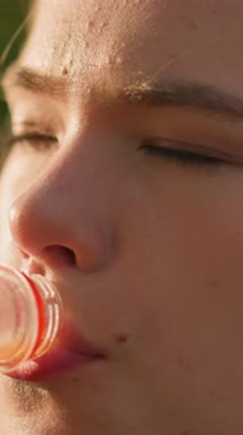 CloseUp of Woman Drinking Orange Juice Outdoors with Relaxed Contentment