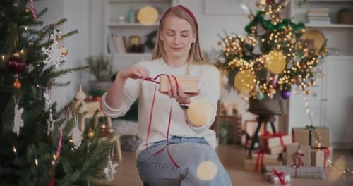 Woman Opens Christmas Gift at Home