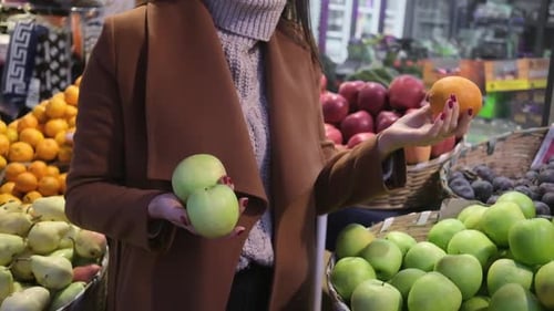Woman in Grocery Store or Supermarket at the Vegetable and Fruit Shelf Shopping for Organic Food