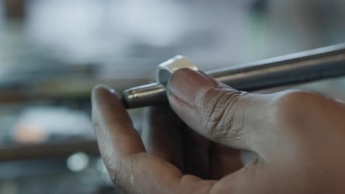 Jeweler Shaping Silver Ring with Hammer and Tools