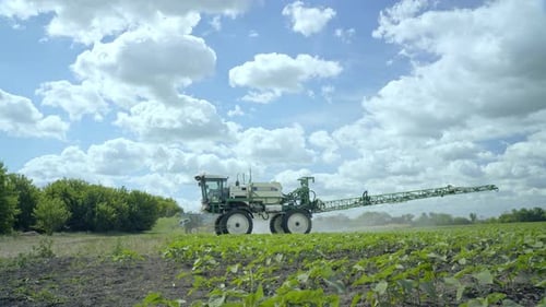 Fertilizer Spreader Working on Field. Spraying Machine Irrigating Farming Field. Agricultural Spraye