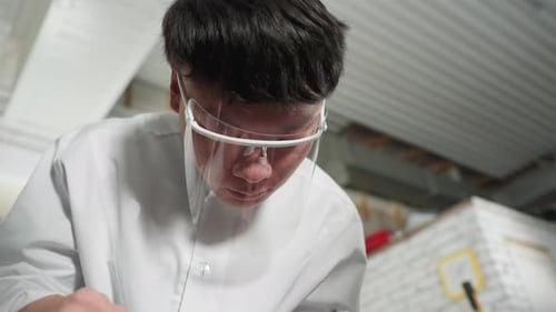 Close Up of Professional in Lab Coat Using Vernier Caliper in Automotive Workshop