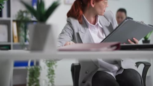 Woman Reviews Paperwork in Bright Modern Office