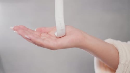 Lotion Being Poured into Palm of Hand