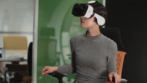 Asian female Using Virtual Reality in creative office