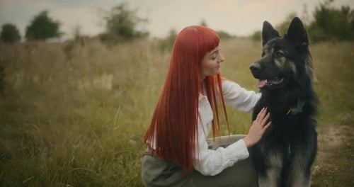 Woman Petting German Shepherd Dog in Field