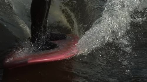Surfer Rides a Surfboard Splashing Water Close Up
