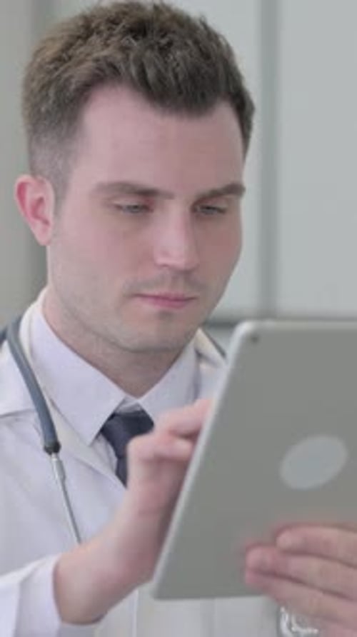 Doctor Working on Tablet in Hospital Setting