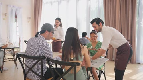 Group of diverse friend talking and eating food together in restaurant.