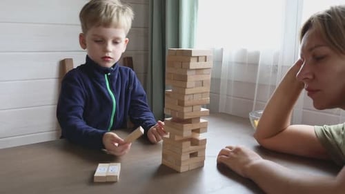 Child Plays Tower Block Game With Adult
