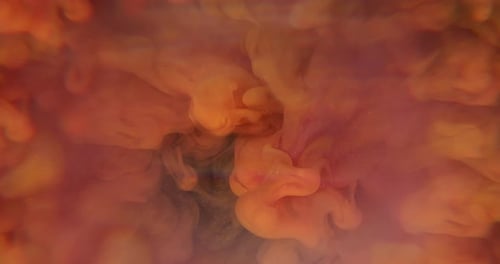 Flowing orange ink dissolving in water abstract