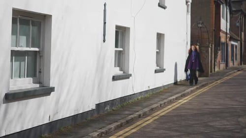 Ginger haired women walking down the street using the pathway