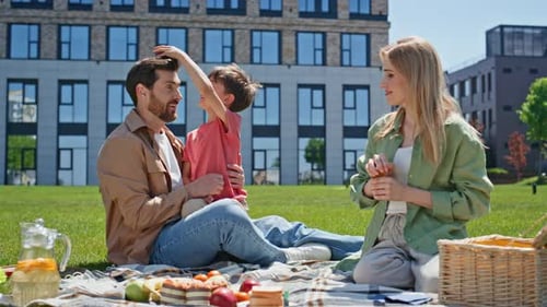 Joyful Parents Spending Time with Child Boy in Park Happy Family Having Fun