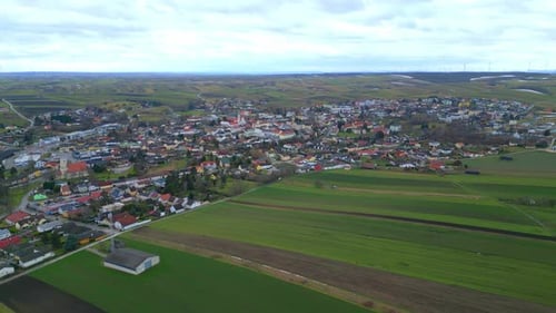 Aerial Panoramic View Of Countryside Town With Vast Evergreen Fields.