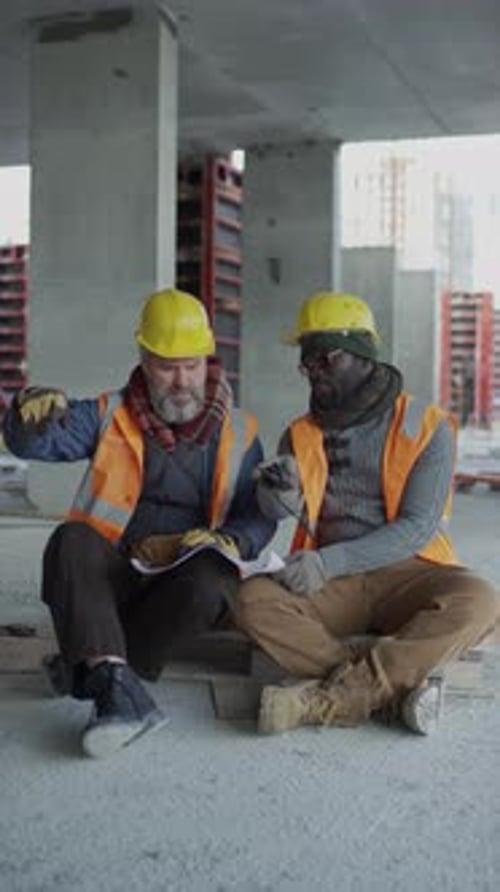 Engineers Discussing Building Plan at Construction Site