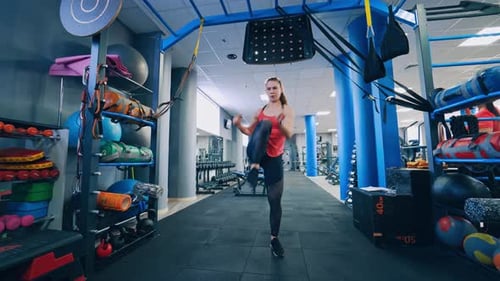 Front view of a sportswoman indoors. Sportive girl training her body in fitness centre.