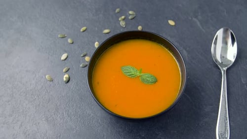 Bowl of soup with seeds and spoon
