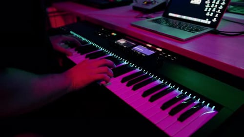 professional recording studio sound engineer or music producer musician pressing synthesizer keys