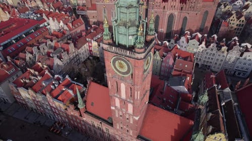 Top Down Aerial Shot of Ancient Cathedral and Clock Tower in European Town with Tiled Red Roofs