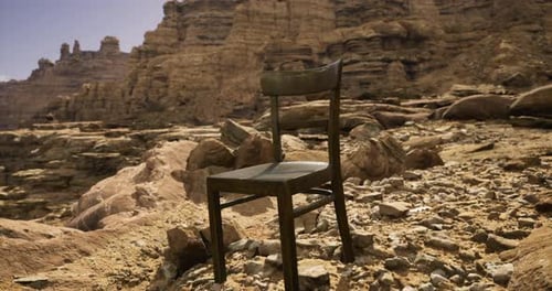 Chair Placed Alone Among Rocky Terrain in a Desert Landscape