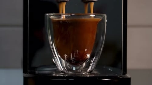 Coffee Pouring into a Glass Cup from Machine