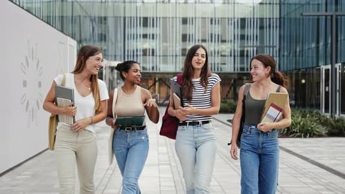 Amigas da faculdade caminhando no campus universitário Jovens estudantes hispânicas e afro-americanas