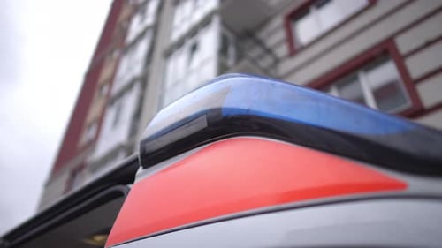 Schrankteile der Tür und blinkende Lichter eines Krankenwagens auf dem Hintergrund eines Hochhauses