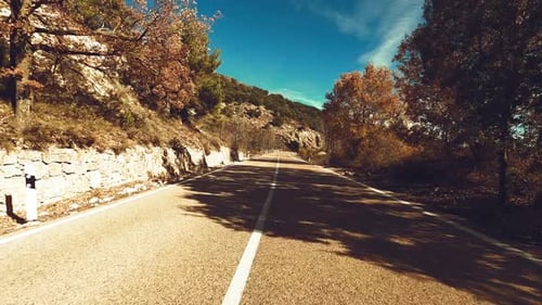 Driving vehicle on a long asphalt straight road in the nature with blue sky