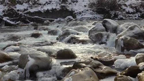 Frozen River Stones in Turquoise Alpine Water Flow Winter