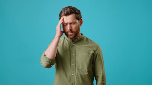 Man Touching Temples Experiencing Headache in Studio
