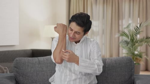Young Adult Man Applying Cream on Arm