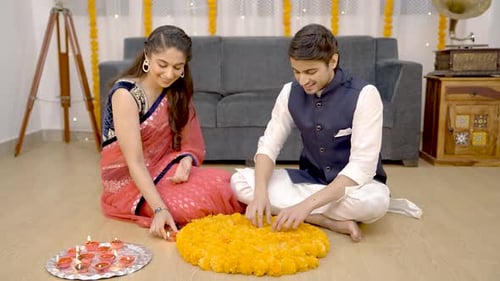 Couple Arranging Candles and Flowers for Diwali