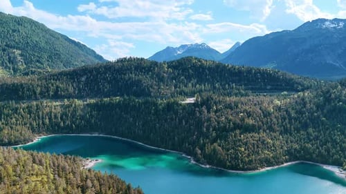 Wunderschöner türkisfarbener See, umgeben von Felsen, die mit Pinienwäldern bedeckt sind.